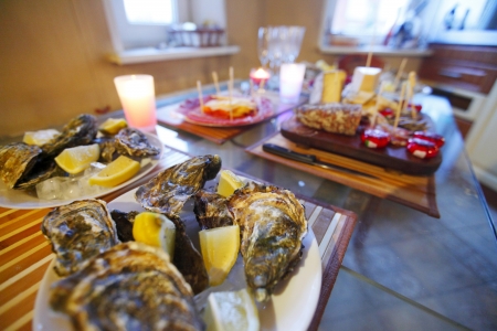 Various sliced sausage, cheese and oysters on tableの写真素材