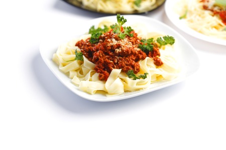 Plates with spaghetti bolognese on white backgroundの写真素材