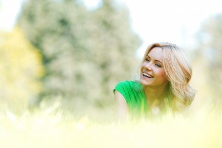 Happy young woman lying on grassの写真素材