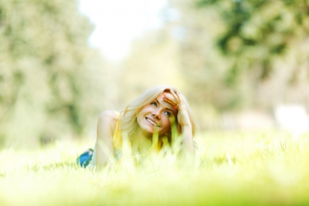 Happy young woman lying on grassの写真素材