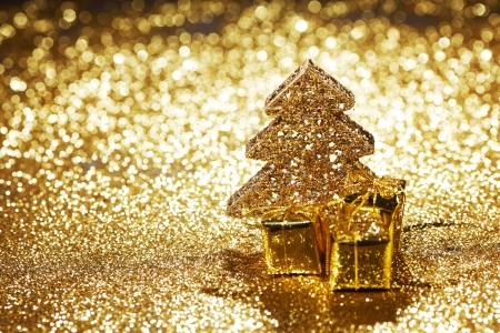 Golden christmas fir tree decoration and gifts on glitter backgroundの写真素材