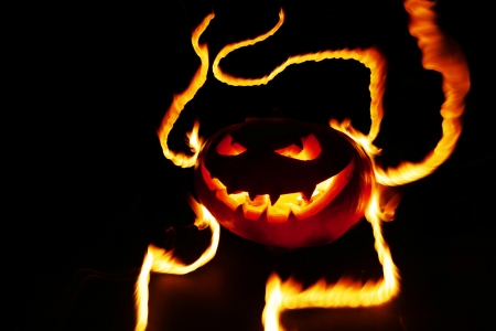 Burning halloween pumpkin on black backgroundの写真素材