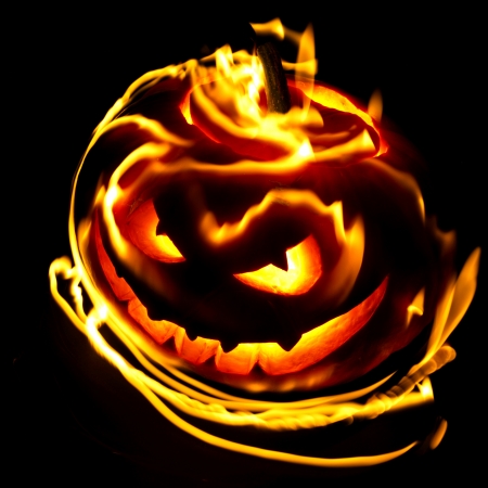 Burning halloween pumpkin on black backgroundの写真素材