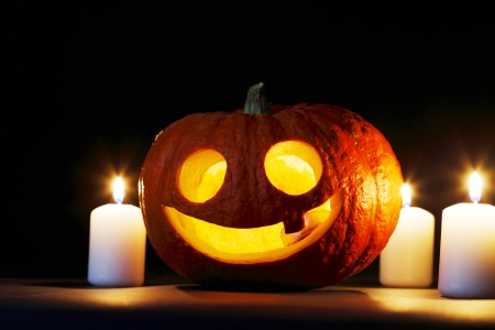 Halloween pumpkins with candles on black の写真素材