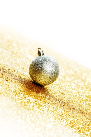 Silver christmas ball on shiny golden の写真素材