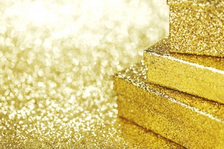 Golden boxes with holiday gifts on shiny glitter backgroundの写真素材