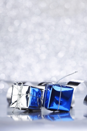 Christmas gifts and decoration ribbon on shiny silver backgroundの写真素材