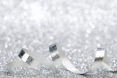 Silver Christmas decoration ribbon on glitter backgroundの写真素材