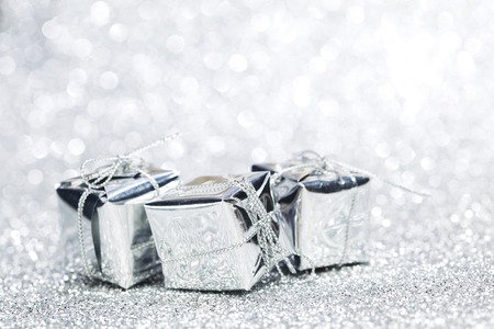 Boxes with christmas gifts on shiny silver backgroundの写真素材