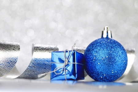 Christmas decoration ball and ribbon on silver glitter backgroundの写真素材