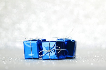 Blue Christmas gift boxes on shiny silver backgroundの写真素材