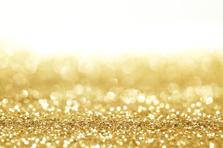 Golden shiny glitter holiday celebration background with white copy spaceの写真素材