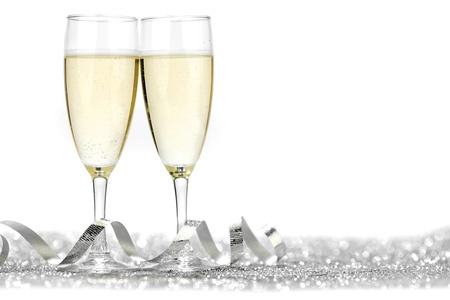 Two champagne flutes and decoration on gold shiny backgroundの写真素材