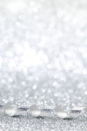 Curly silver gift ribbon on shiny background close-upの写真素材