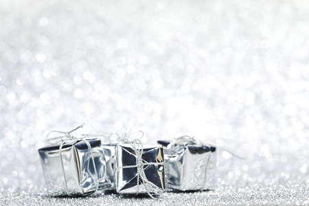Boxes with christmas gifts on shiny silver backgroundの写真素材