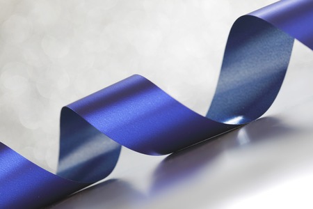 Card with blue gift bow on shiny silver backgroundの写真素材