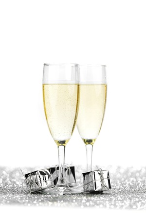 Two champagne flutes and gifts on shiny backgroundの写真素材