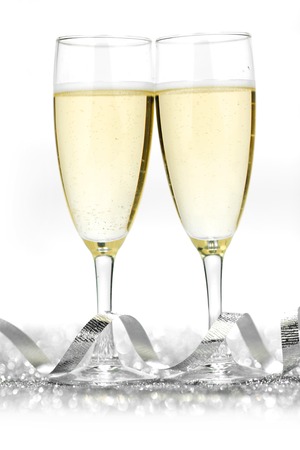 Two champagne flutes and decoration on gold shiny backgroundの写真素材