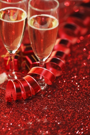 Champagne and holiday gifts on red glitter backgroundの写真素材