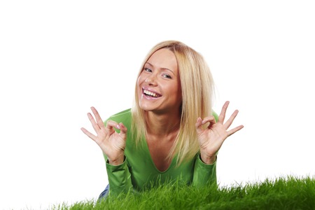 Woman laying on grass, isolated on whiteの写真素材