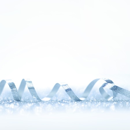 Curly silver gift ribbon on glitters background close-upの写真素材