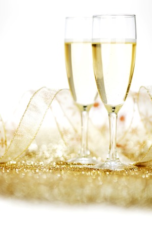 Two glasses of champagne with bow on golden backgroundの写真素材