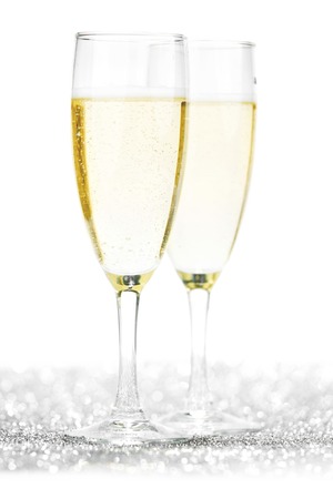 Pair of champagne flutes on shiny glitter backgroundの写真素材