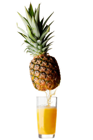 Juice pouring from pineapple into glass isolated on white backgroundの写真素材