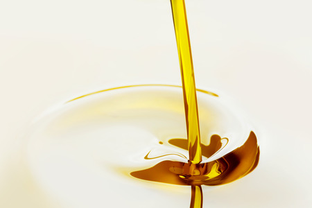 Pouring liquid golden oil close up viewの写真素材