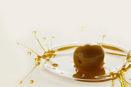 Splash of olive fruit in oil close-up viewの写真素材