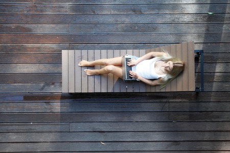 young woman lying on wooden sunbedの写真素材