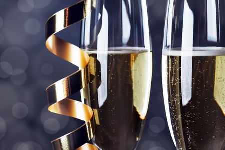 Two champagne glasses and curly ribbons on dark backgroundの写真素材