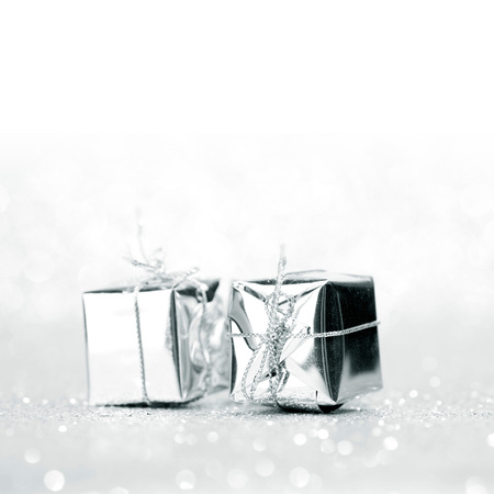 Decorative silver boxes with holiday gifts on shiny glitter backgroundの写真素材