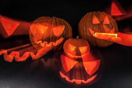 Funny glowing Halloween pumpkins on a black backgroundの写真素材