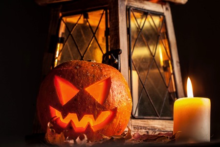 Halloween pumpkin and lantern with candle on black background