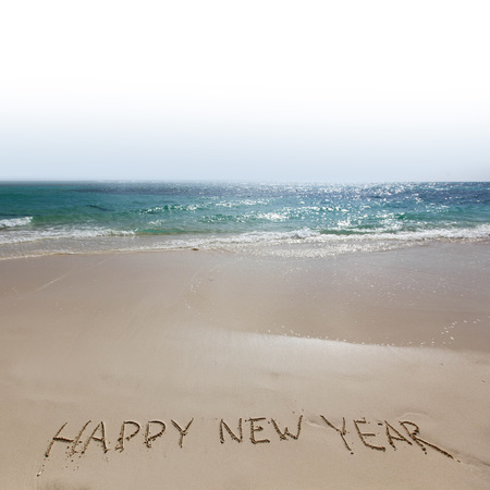 Happy new year handwriting on tropical sea beach