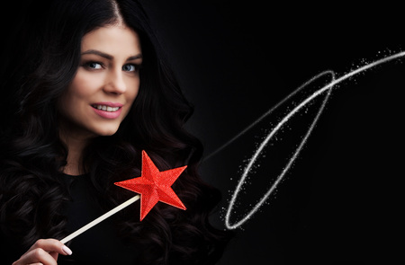 Woman with star shaped magic wand and sparksの写真素材