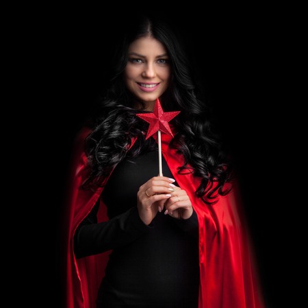Woman with star shaped magic wand on blackの写真素材