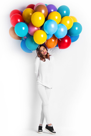 Happy woman with many colorful balloonsの写真素材