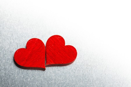 Two wooden red painted Valentine day hearts on metal backgroundの写真素材