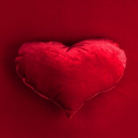 Red pillow heart on red fabric background, Valentines dayの写真素材