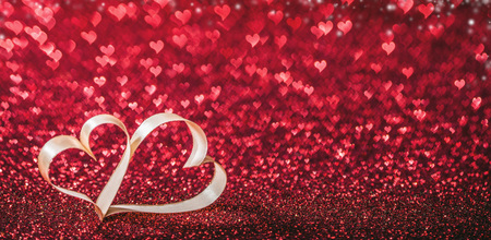 Two ribbon hearts on glowing bokeh lights backgroundの写真素材