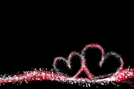 Two magic hearts of red ribbon and glowing lights on black backgroundの写真素材