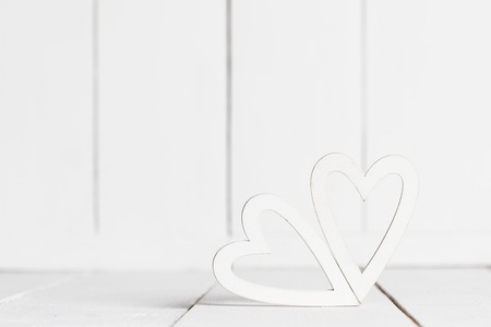 Two decorative white hearts on wooden backgroundの写真素材