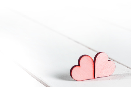 Two small red hearts on white wooden backgroundの写真素材