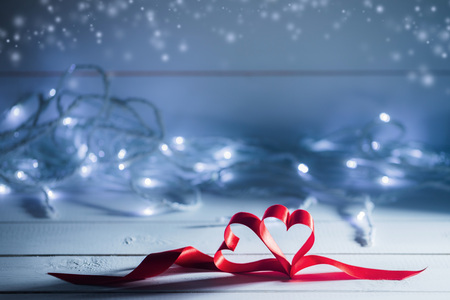 Valentines day ribbon hearts on glowing garland defocused bokeh lights backgroundの写真素材