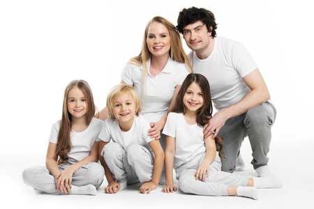 Studio portrait of family in white clothes with three children isolated on white backgroundの写真素材