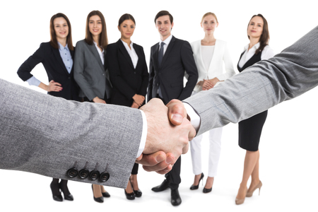 Closeup of business handshake, team of business people on background, isolated on whiteの写真素材
