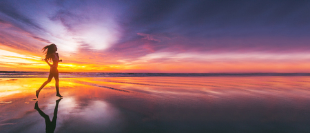 Woman running on the beach at sunset in bikini. Bali island, Indonesiaの写真素材