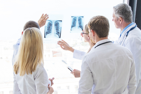 Group of doctors look and discuss x-ray in a clinic or hospital